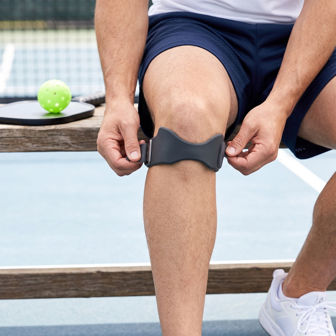 Player adjusting CourtBrace Pro knee support courtside